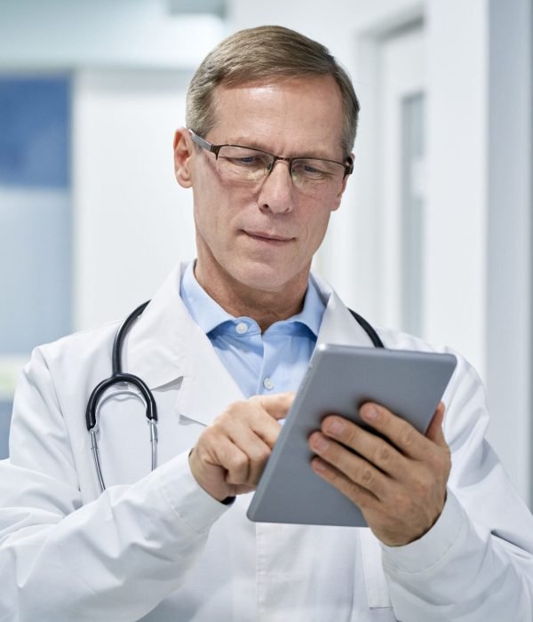 Doctor checking tablet for his patient appointments