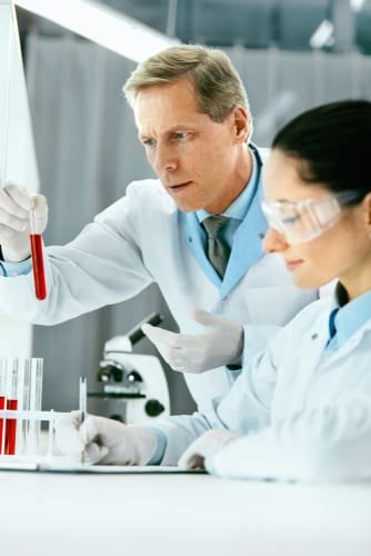 male and female pathologists analysing blood test samples of a patient